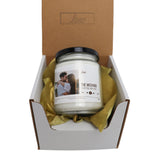 a candle in a box with a yellow ribbon around it