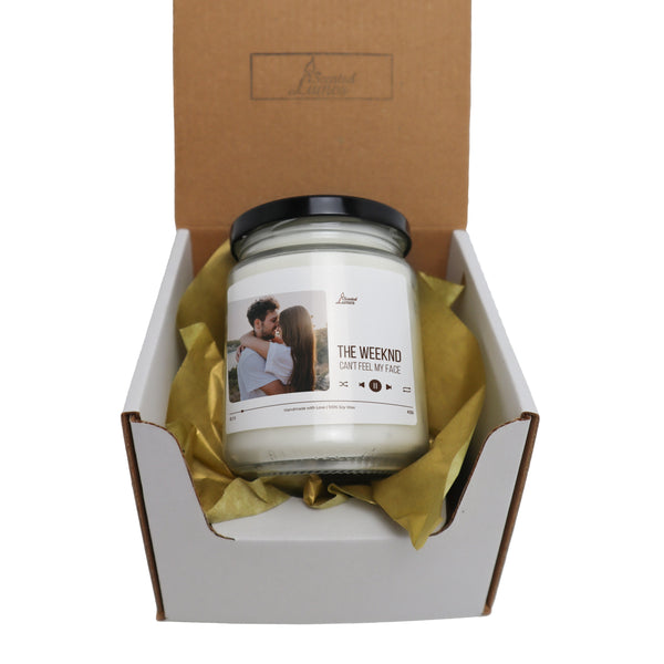 a candle in a box with a yellow ribbon around it