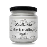 a white jar with a black lid that says smell like she is reading again