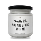 a white jar with a black lid that says smells like you are stuck with me