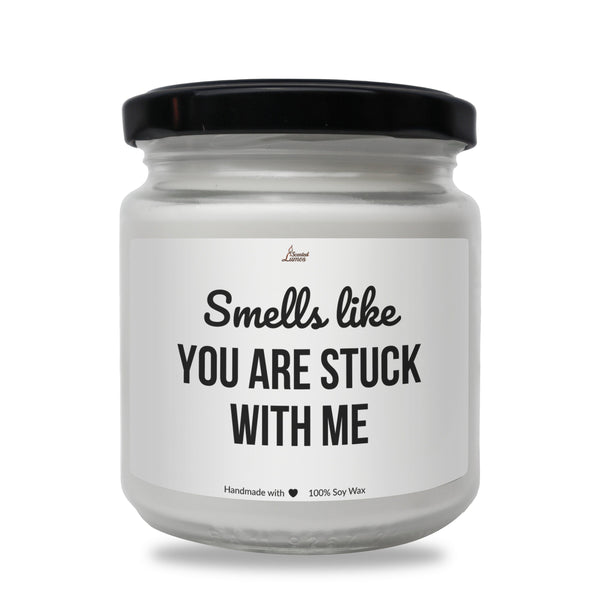 a white jar with a black lid that says smells like you are stuck with me