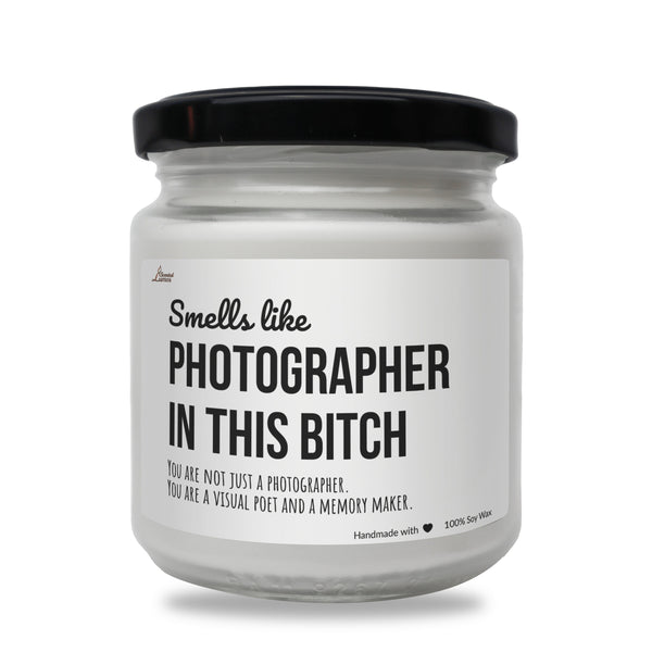 a white jar with a black lid that says, smell like photographer in this bitch