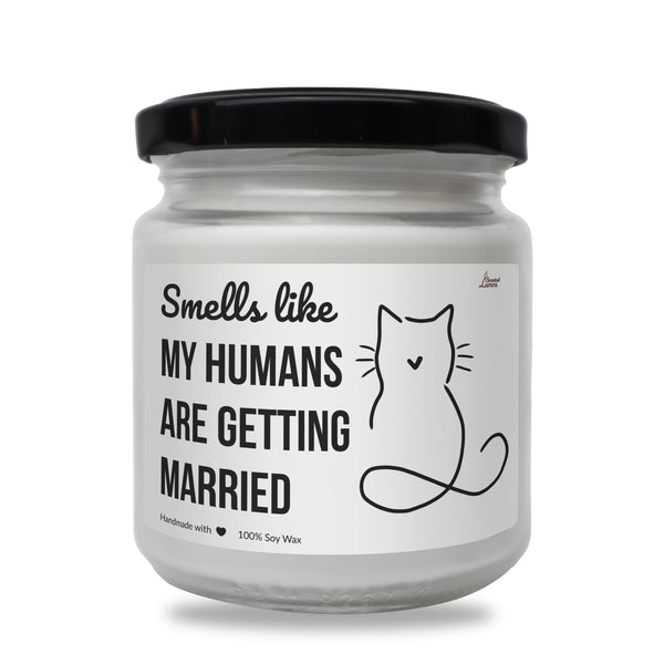 a white jar with a black lid that says smells like my humans are getting married