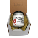 a candle in a box with a ribbon around it