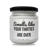 a jar of white candles that says smell like your thirties are over