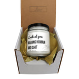 a white jar with a black lid sitting inside of a cardboard box