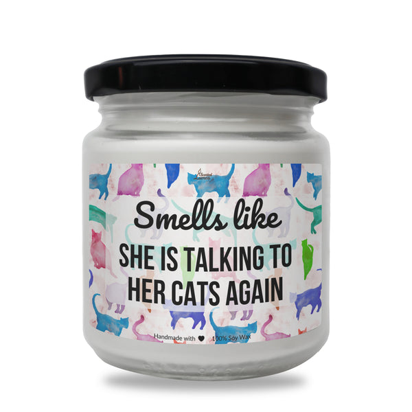 a white jar with cats on it that says smell like she is talking to her
