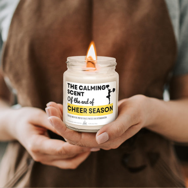 a person holding a jar of cheer season candles
