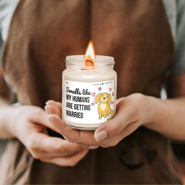 a person holding a candle with a dog on it