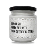 a white jar with a black lid that says do not sit on my bed with