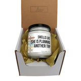 a candle in a box with a brown ribbon around it