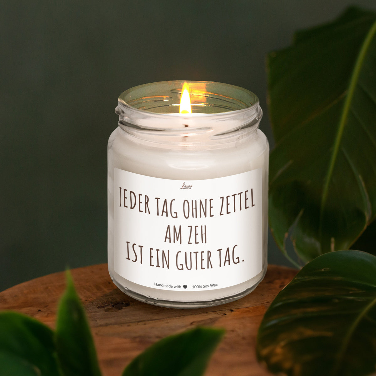 a lit candle sitting on top of a wooden table