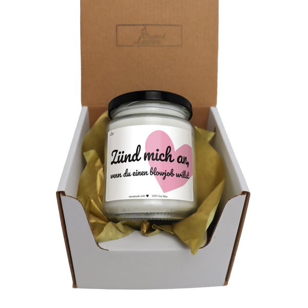 a candle in a box with a heart on it