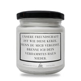 a jar of white candles with a black lid