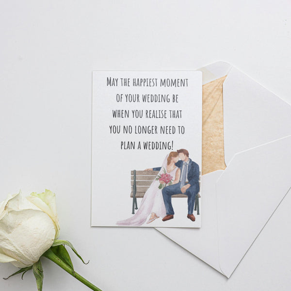 a card with a picture of a bride and groom sitting on a bench