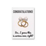 a card with two gold rings and a bow on it