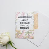 a white rose sitting next to a piece of paper