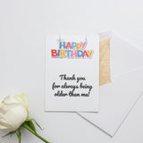 a white rose sitting next to a piece of paper