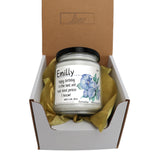 a candle in a box with a ribbon around it