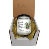 a candle in a box with a ribbon around it