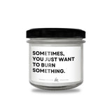 a white jar with a black lid that says sometimes you just want to burn something