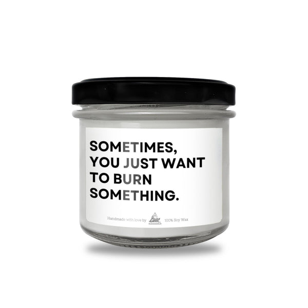 a white jar with a black lid that says sometimes you just want to burn something