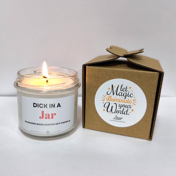 a candle in a glass jar next to a box