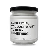 a white jar with a black lid that says sometimes you just want to burn something
